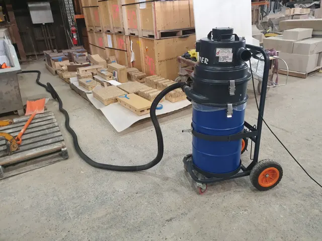 Dirt Eater Jr compact HEPA industrial vacuum in action on a jobsite